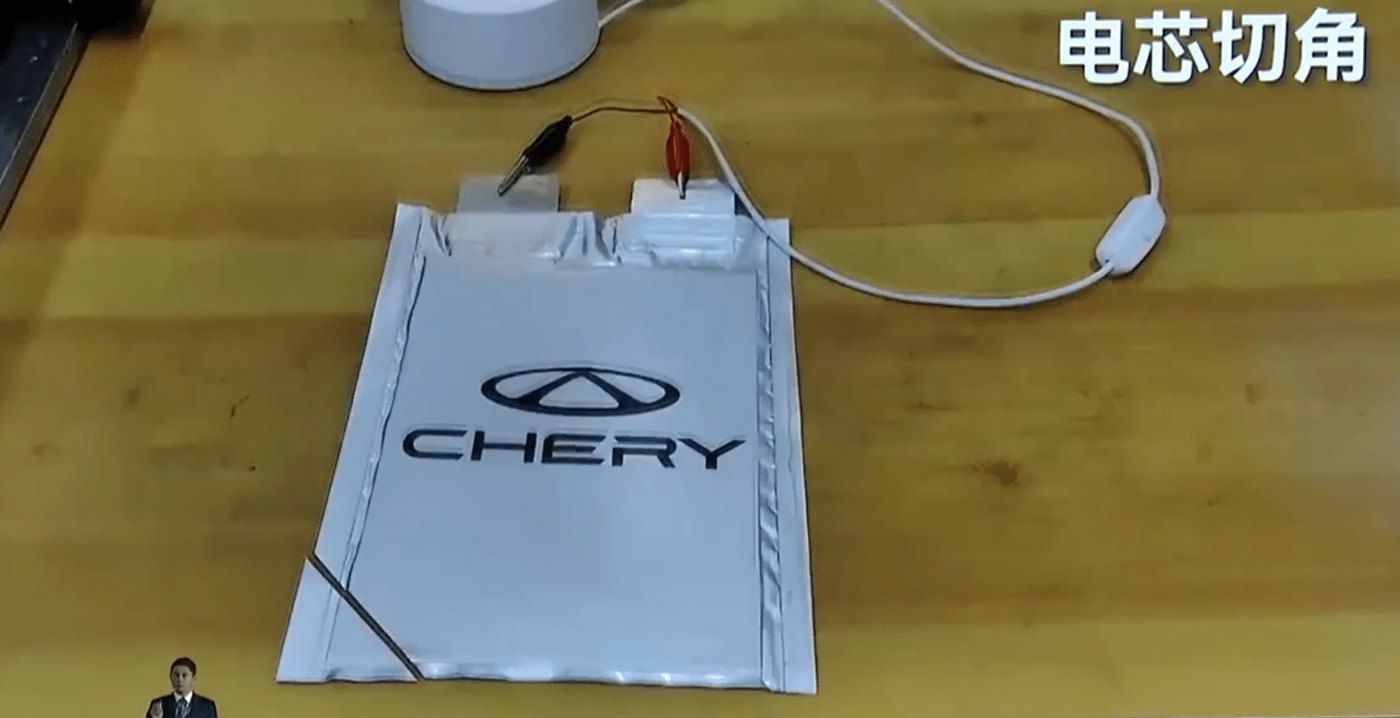 Твердотельный элемент Chery с логотипом на столе, подключённый проводами к измерительному устройству